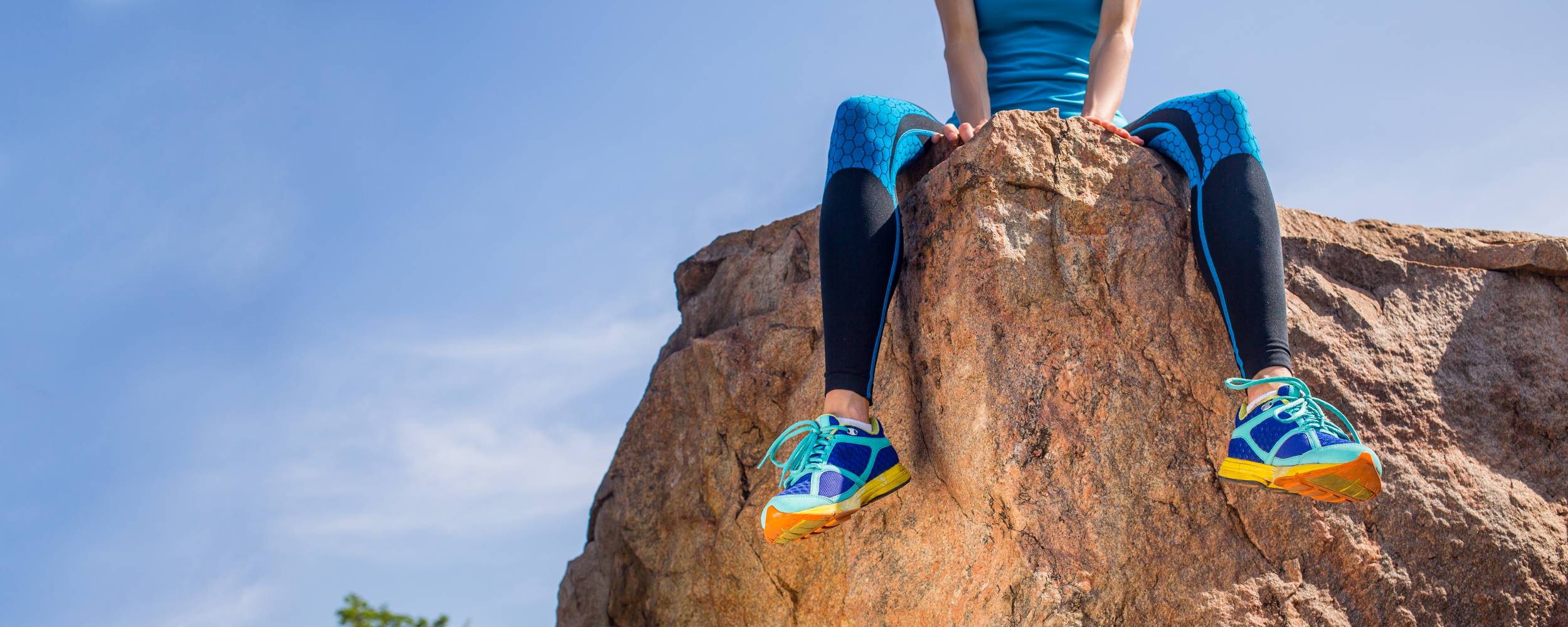 A woman relaxing on a mountain peak.