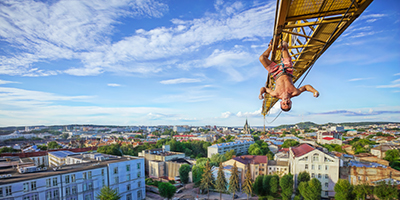 A climber hanging from a crane.